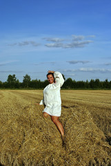 girl in Russian costume sitting on a haystack and smiling