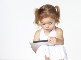 Cute little girl  is playing concentrated with touchpad