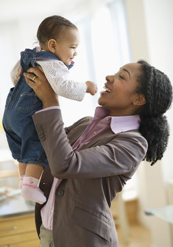 Mixed race woman lifting baby