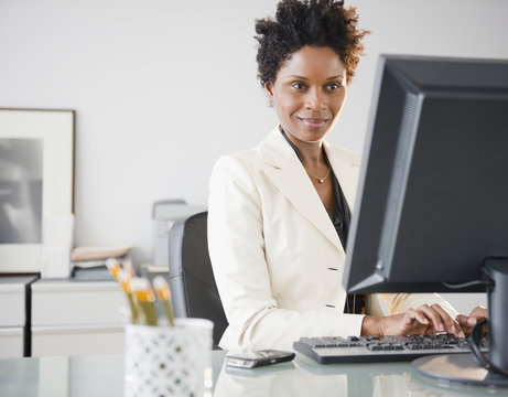 Black businesswoman typing on computer at desk