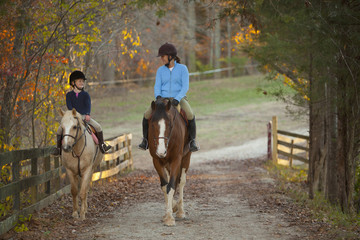 Caucasian girl and trainer riding horses