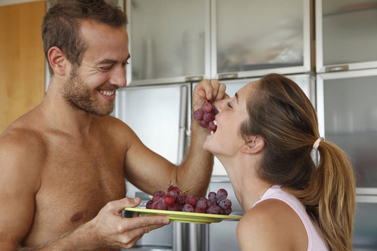 Caucasian man feeding wife grapes