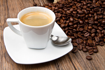 Coffee cup with roasted beans on rustic table