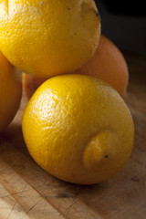 Lemon on wooden chopping board, ready for preparation to eat..