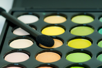 multicolored eye shadows with cosmetics brush