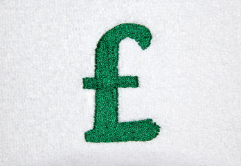 green pound currency symbol embroidered on white cloth