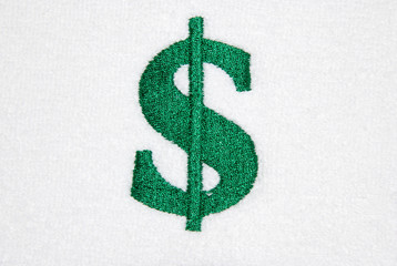green dollar currency symbol embroidered on white cloth