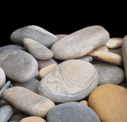 Fototapeta na wymiar Many smooth sea stones isolated on black closeup