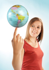Junge Frau balanciert einen Globus auf dem Finger