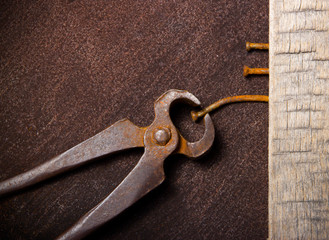 Old vintage clip pull up nail on the grunge rusty background.