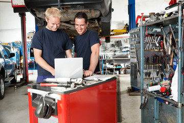 Mechanics with laptop in garage