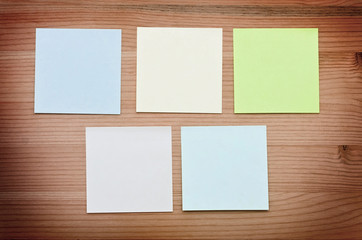 Multi-colored notes on a wooden background