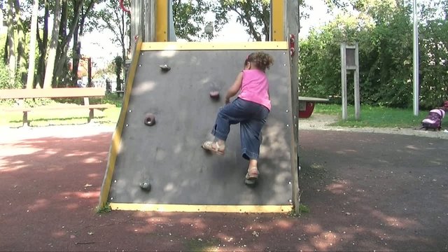 Jeune fille escaladant un jeu dans un parc