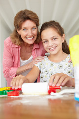 Obraz na płótnie Canvas Young girl baking with grandmother