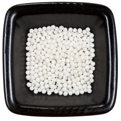 sugar homeopathy balls on black plate close up