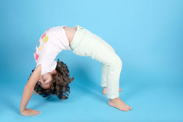 beautiful girl gymnast doing the bridge, studio photo