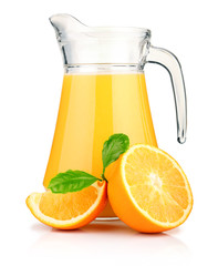 Jug of orange juice and orange fruits with green leaves