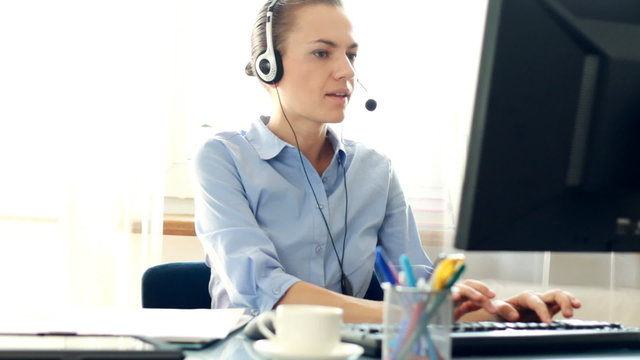 Attractive helpdesk consultant talking on headset