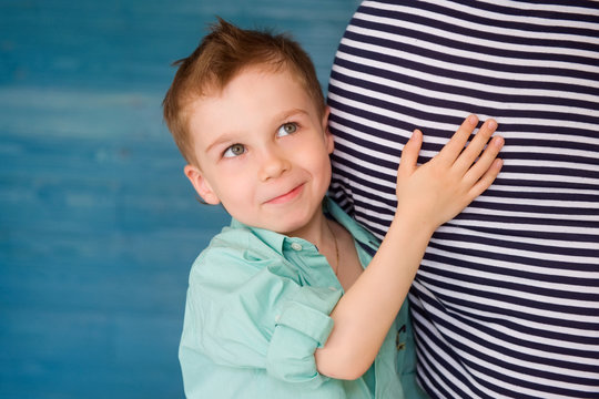 child Listening to pregnant woman's stomach