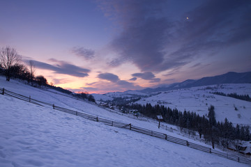 Sunrise in winter mountains with moon
