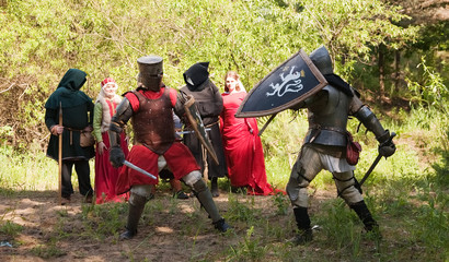 Two knights in armor is fighting