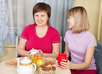 girls  drinking tea and gossiping in home