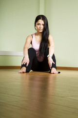 A girl with long black hair sitting on the floor