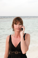 Donna al mare che parla al telefono