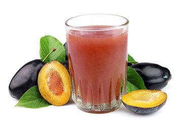 Fresh plums and a glass full of plums juice