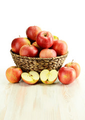 Apples in wicker basket isolated on white