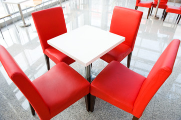 four red chairs at a table