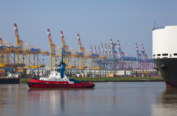 tug with heavy ship in the harbour