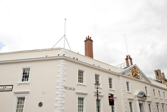 An old white building with Royal Family Coat of Arms