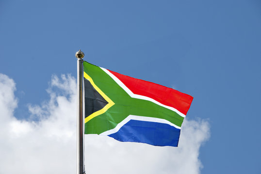 South African Flag on a flagpole against a blue sky