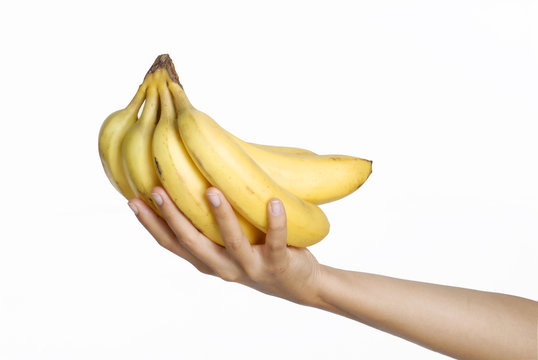 Mano sosteniendo un racimo de bananas.