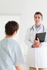 Doctor talking to a cute woman in hospital gown
