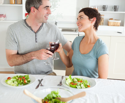 Close up of a cute couple toasting with redwine