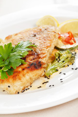Grilled fish fillet with tomato and lemon
