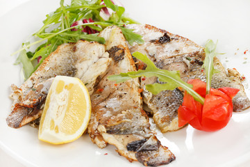 Grilled fish fillet with tomato and lemon