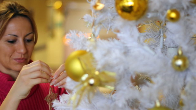 Beautiful woman decorating Christmas tree