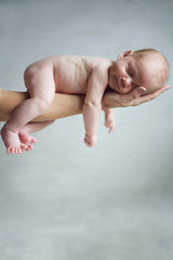 New born baby resting on mom's hand.