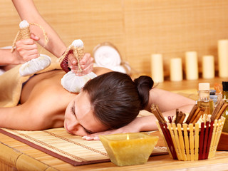 Woman getting massage in bamboo spa.