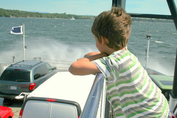 Boy watching waves hit the cars