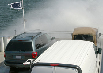 Water spray from a storm on cars on a ferryboat