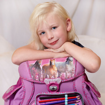 Cute blond child is happy to start at school