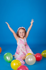 Fototapeta na wymiar Happy child with colorful air ballons over blue
