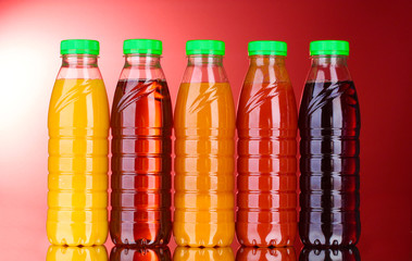 Bottles with juice on red background