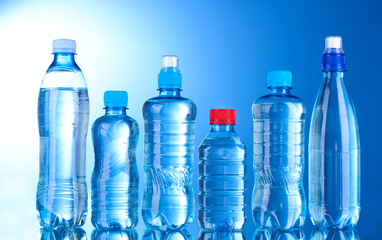 Group plastic bottles of water on blue background