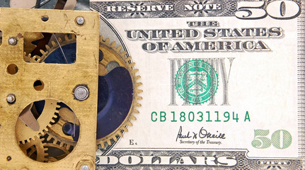 Time is money concept (old watch mechanism and dollar bills)