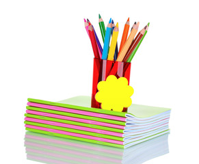 Fototapeta premium Bright pencils in red holder and notebooks isolated on white